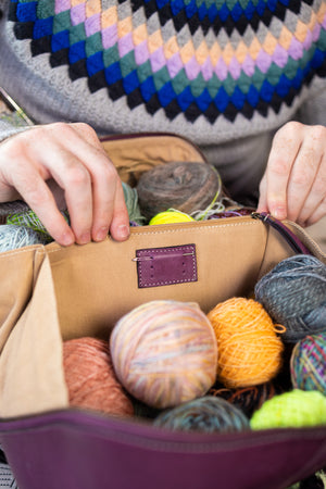 This image shows Project 10 - Aubergine, filled with yarn and needles. The bag is part of a collaboration between Re:Designed and Westknits.