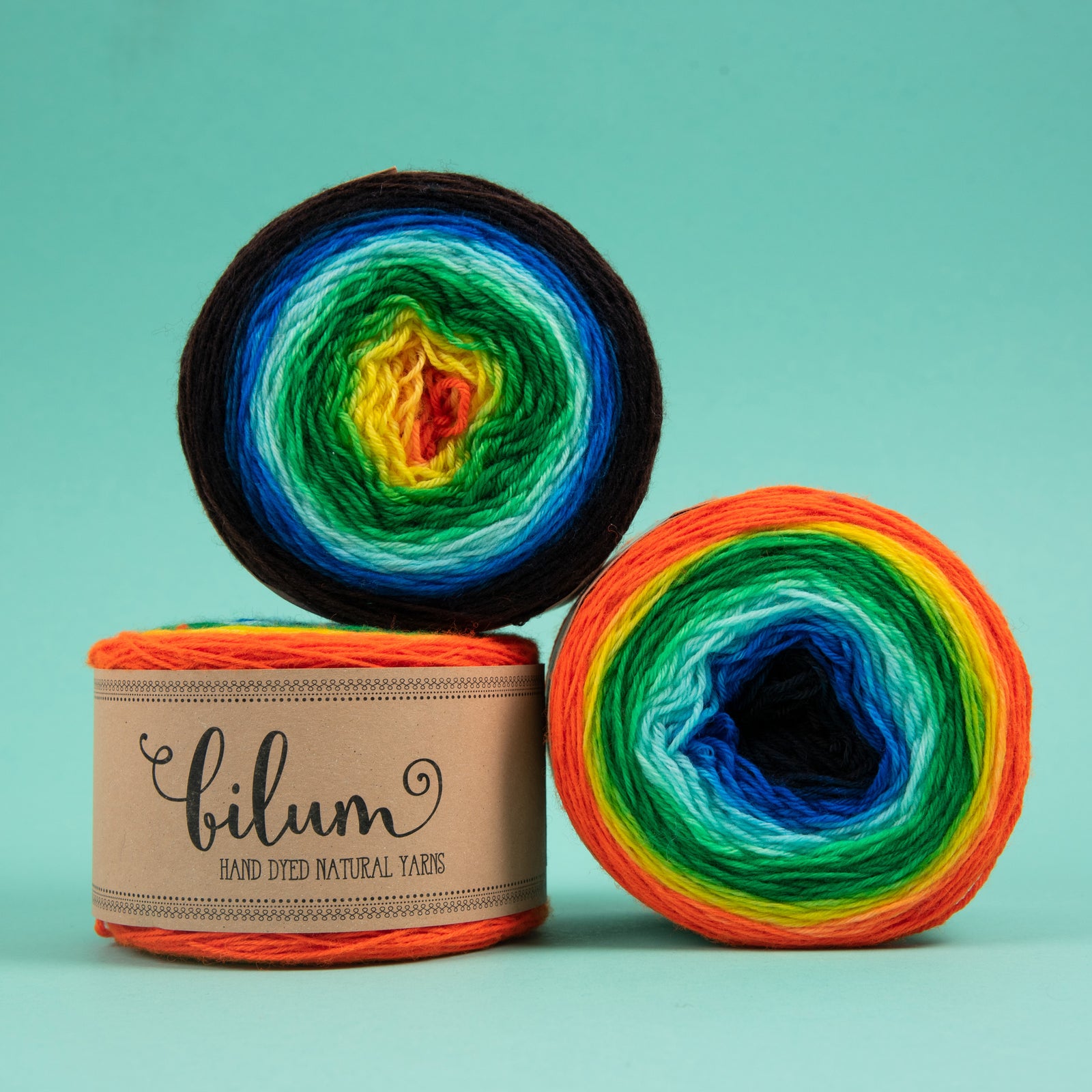 This image shows 3 cakes of LOLI by Bilum in rainbow tones on a green background.