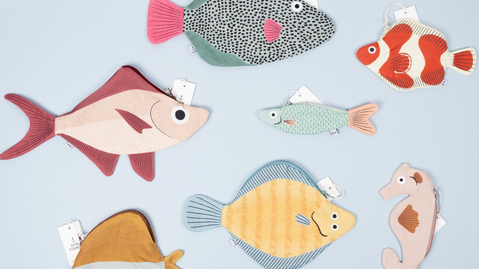Various Don Fisher fish pouches and cases on a light blue background.