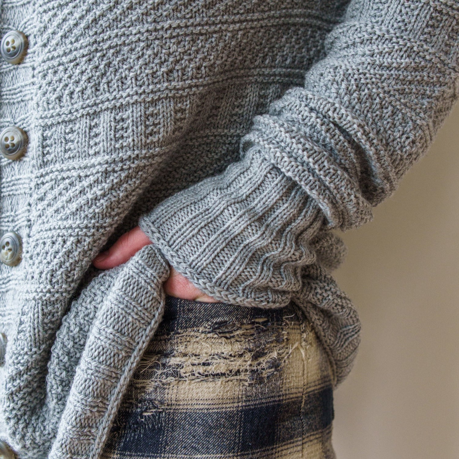 This image shows Stephen West wearing a beautifully knitted sample of the Dustland Cardigan in grey.