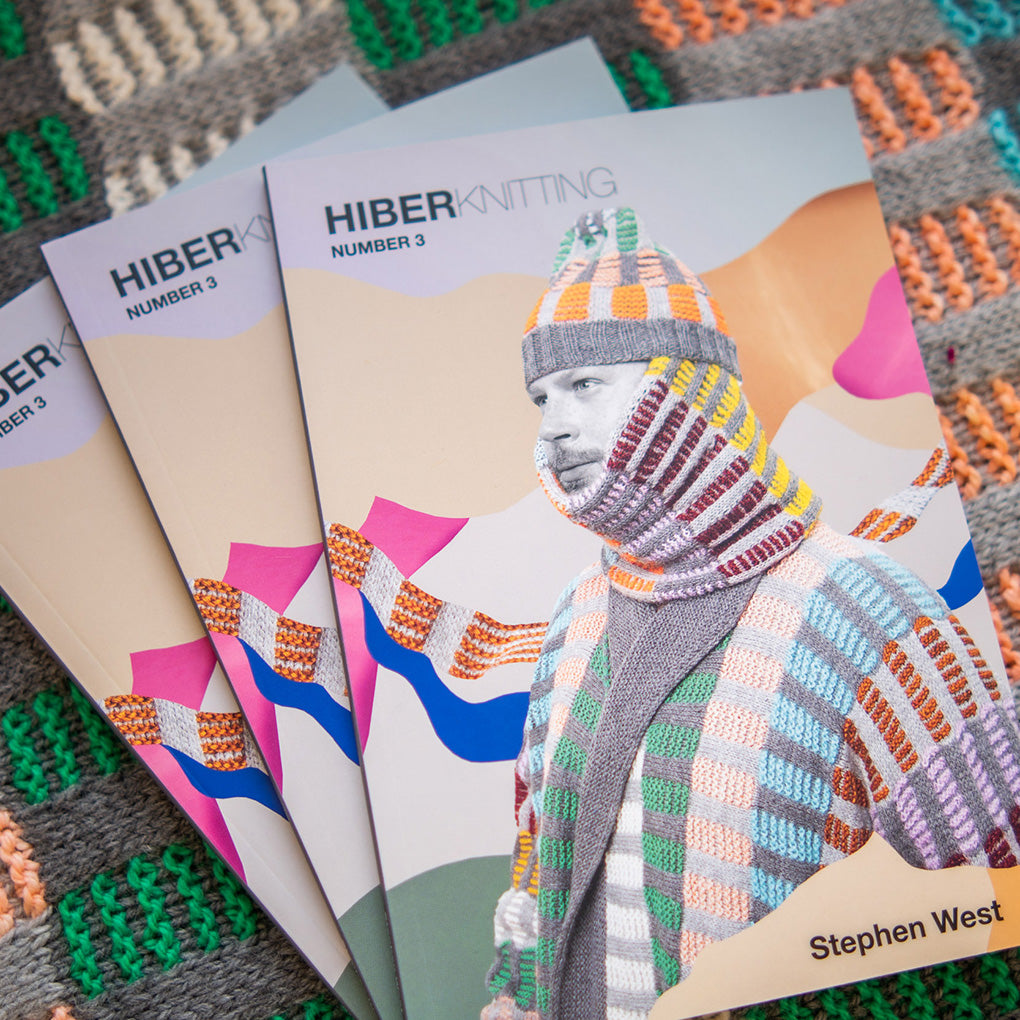 3 books for Stephen West's Hiberknitting 3. Books laid on a knitted background.