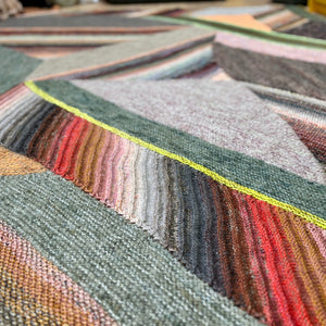This image shows a detail of a sample of the beautifully knitted Marled Magic Blanket from Westknits. The blanket is knitted with various colours and has a patchwork layout.