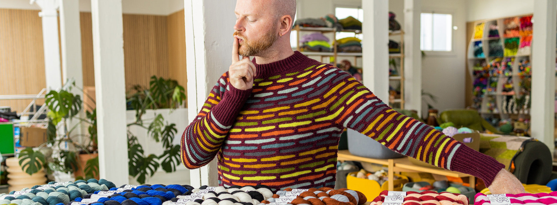 This image shows Stephen West choosing yarn.