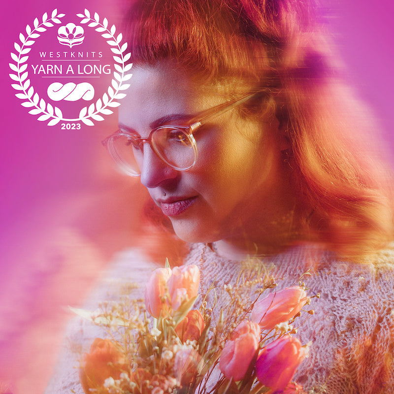 Image shows Dea holding a flower bouquet. She is watching down and is against a pink background. An artistic blur is surrounding her.  A white Westknits YAL logo is on the top left corner.