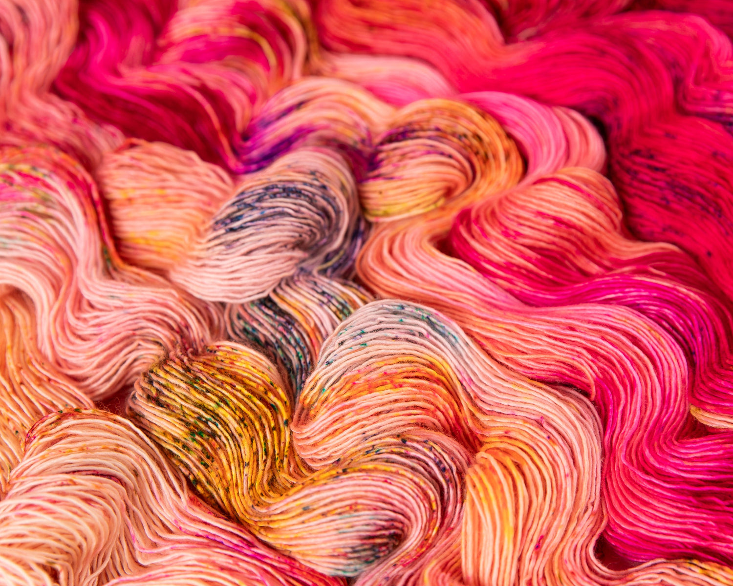 Close-up of colorful yarn with pink, orange, and multicolor shades.