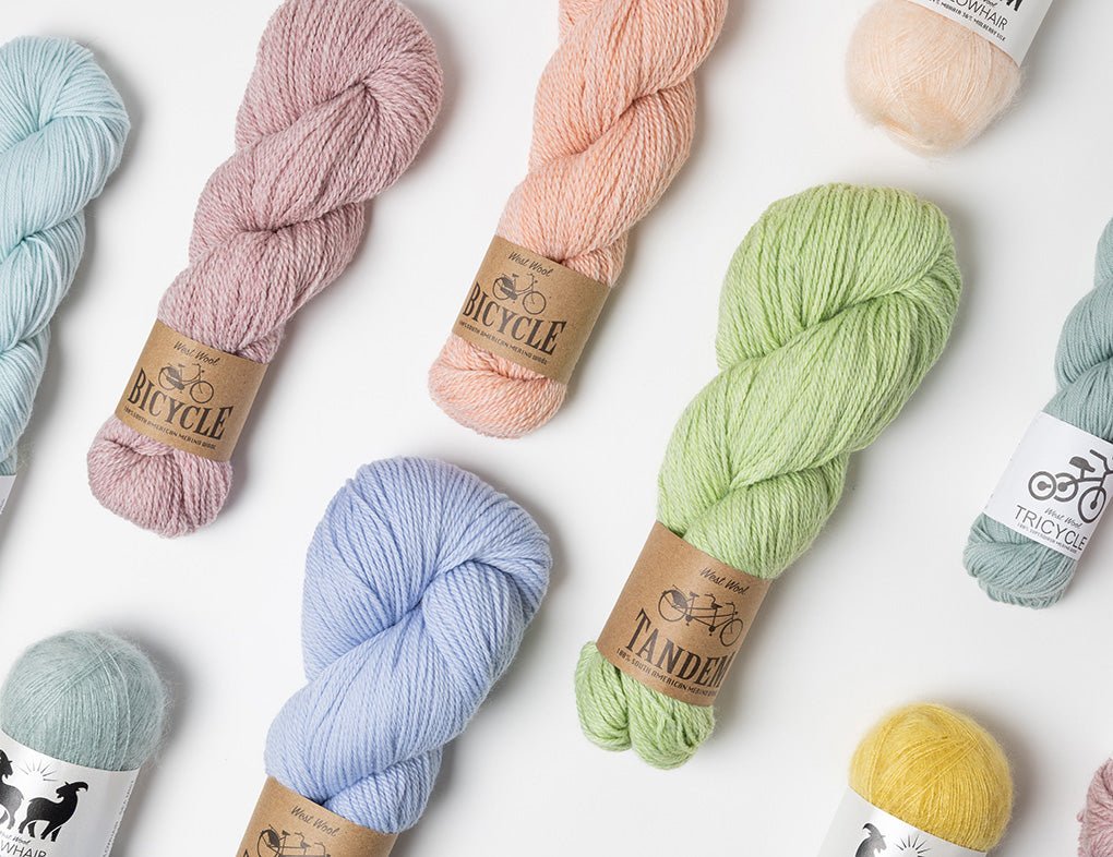 This image shows a selection of pastel colours from all the bases of West Wool on a white background. 