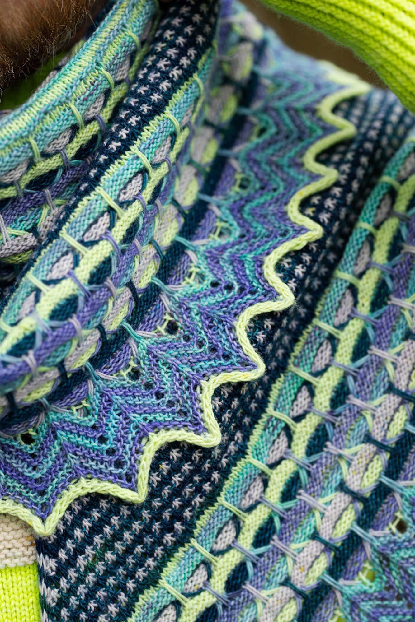 This image shows a detail of the Aurora Cabin Shawl from Westknits in cool shades. 