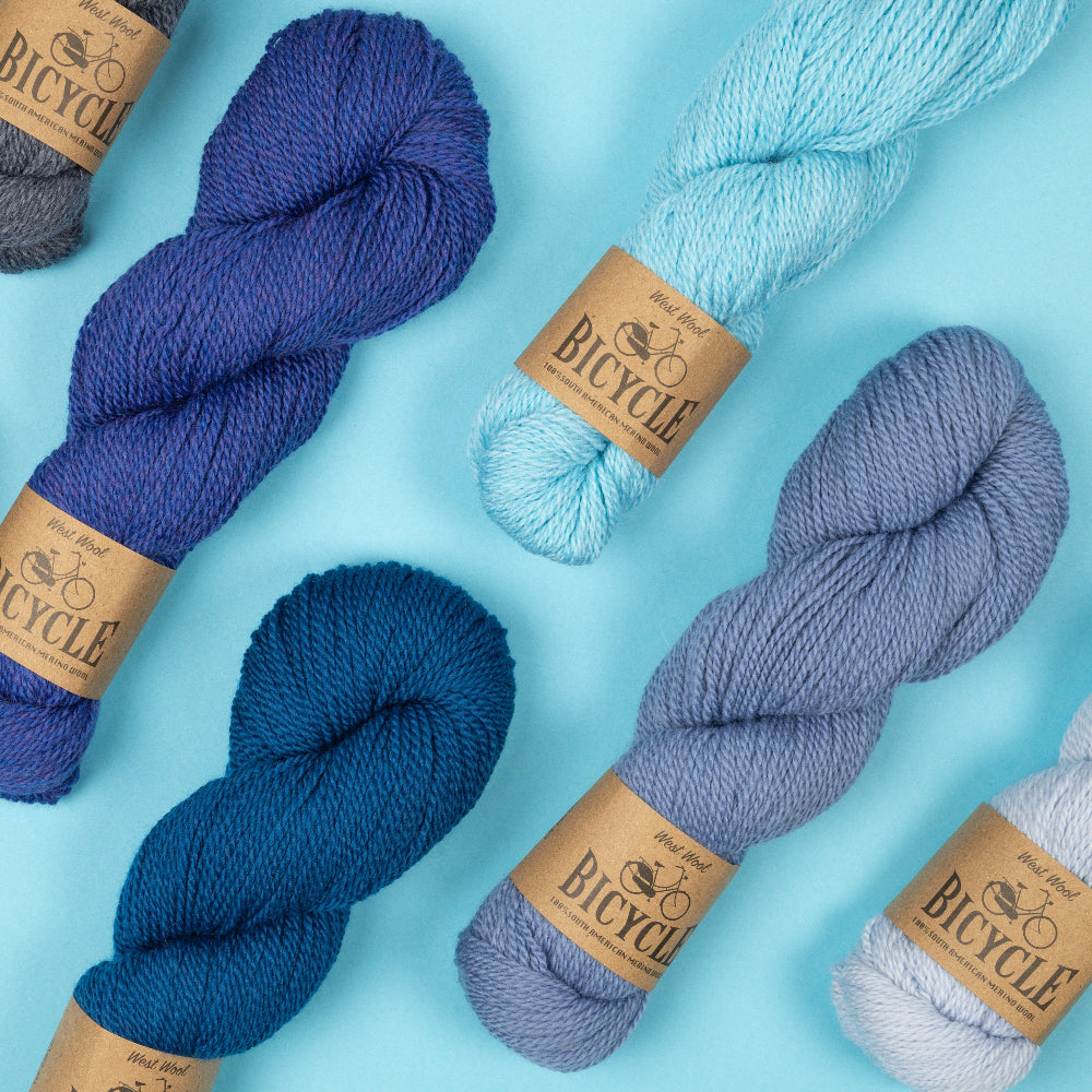This image shows the new blue colours of Bicycle from West Wool on a pastel blue background.