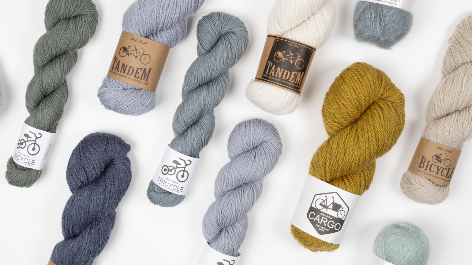 Assorted skeins of West Wool yarn in various colours on a white background
