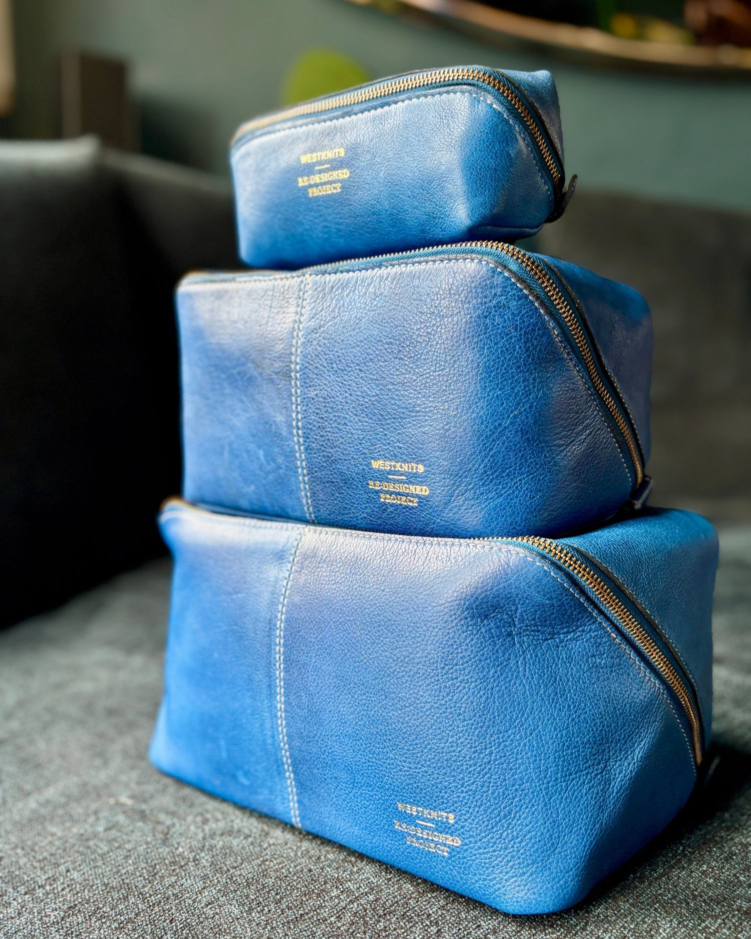 This image shows 3 denim project bag from the Westknits x Re:Designed collaboration stacked on top of each other. 
