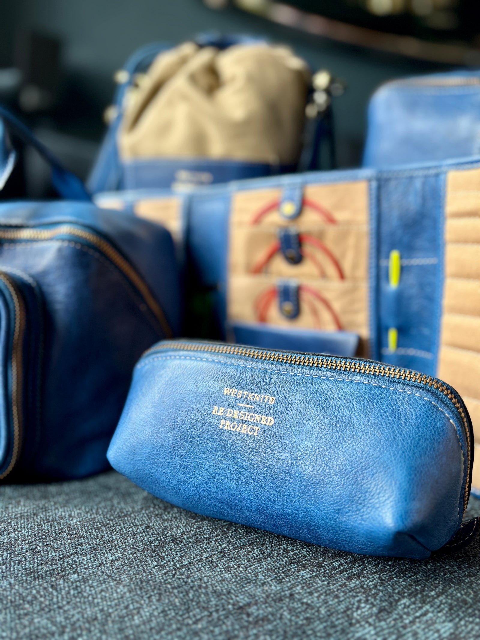 This image shows a small denim project bag from the Westknits x Re:Designed collaboration. 
