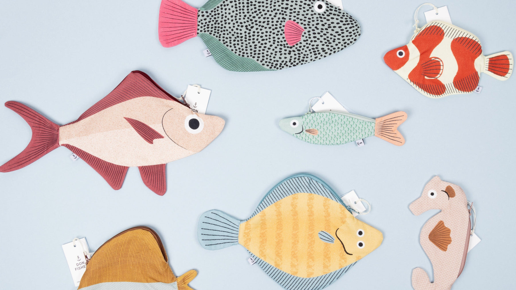 Various Don Fisher fish pouches and cases on a light blue background. 