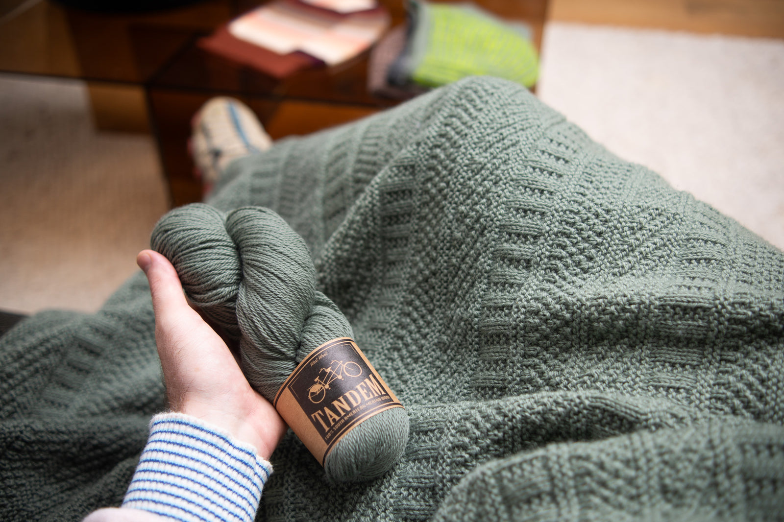 This image shows a detail of a beautifully knitted sample of the Dustland Blanket by Westknits in dusty green yarn. 