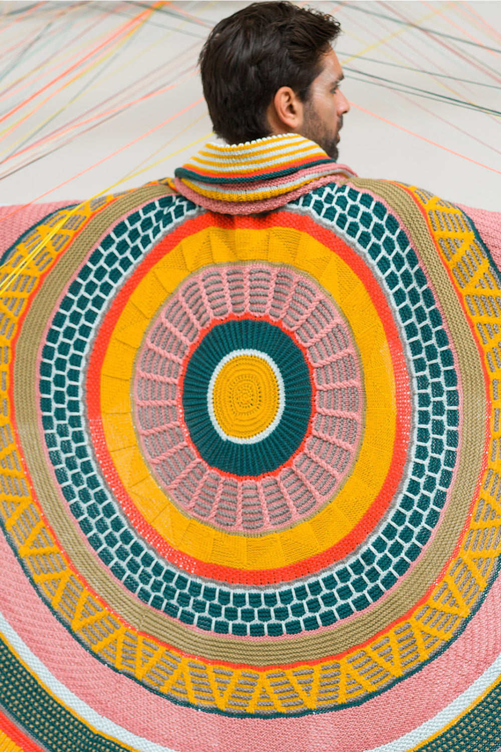 This image shows a beautifully knitted sample of the Fantastitch Blanket by Westknits in various colours, including green, pink, yellow, and coral tones. 