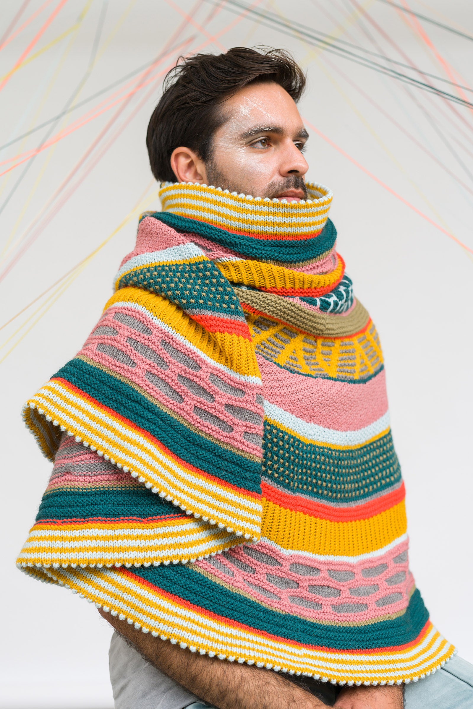 This image shows a beautifully knitted sample of the Fantastitch Blanket by Westknits in various colours, including green, pink, yellow, and coral tones. 