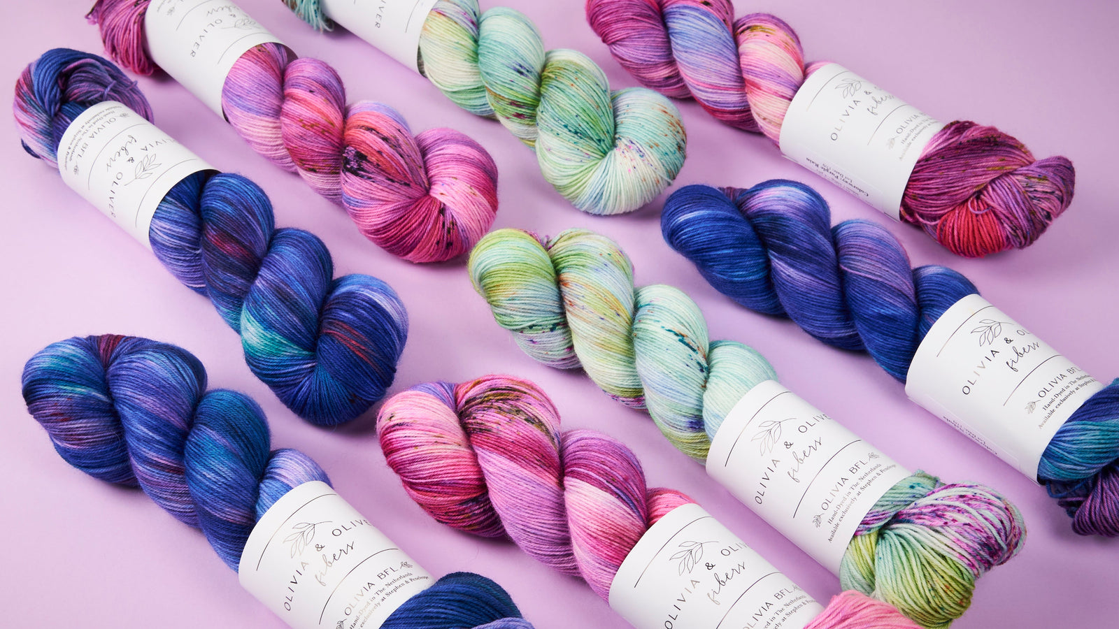 Colorful yarn skeins on a light purple background