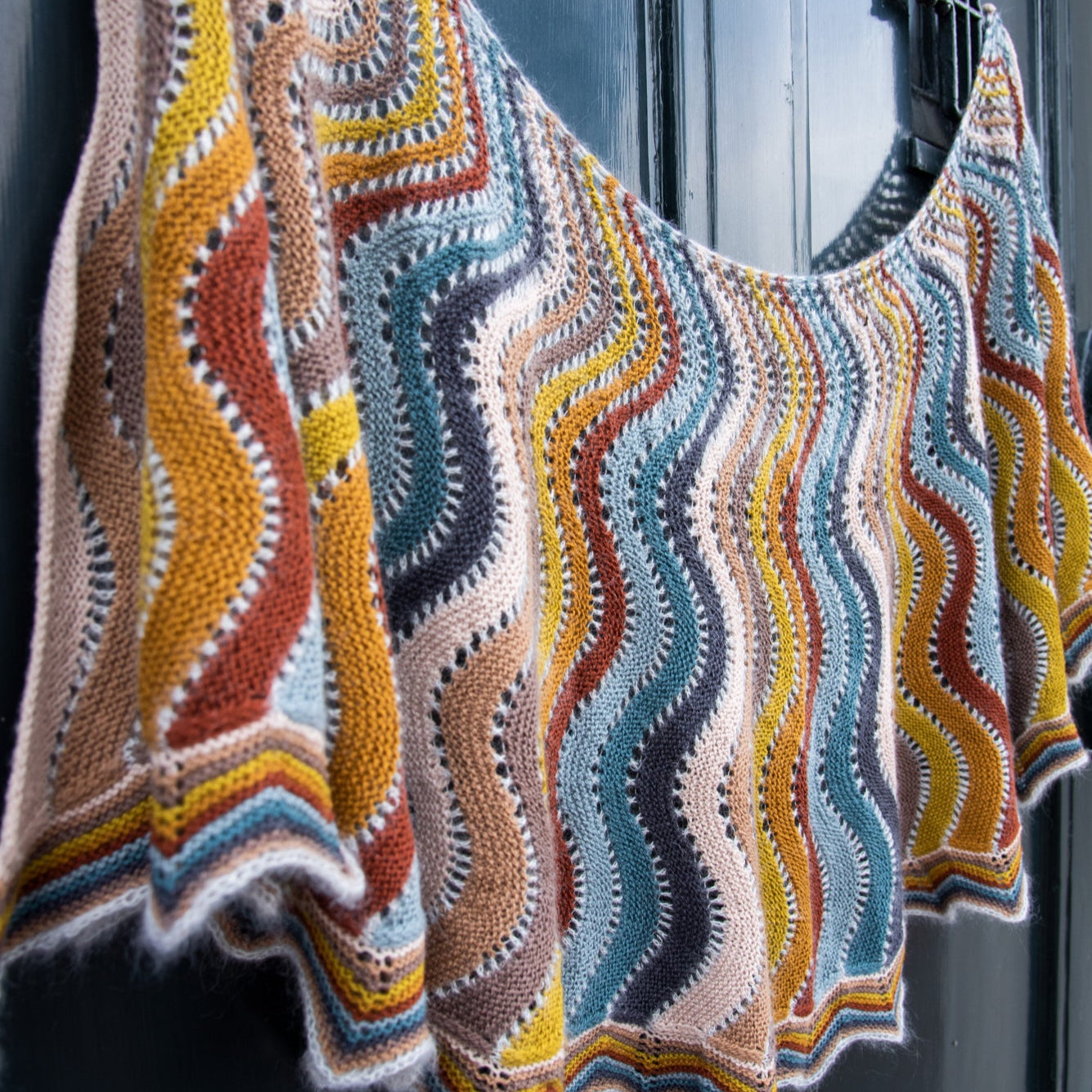 This image shows a beautifully knitted multicolour sample of the Replendence Shawl by Westknits. 