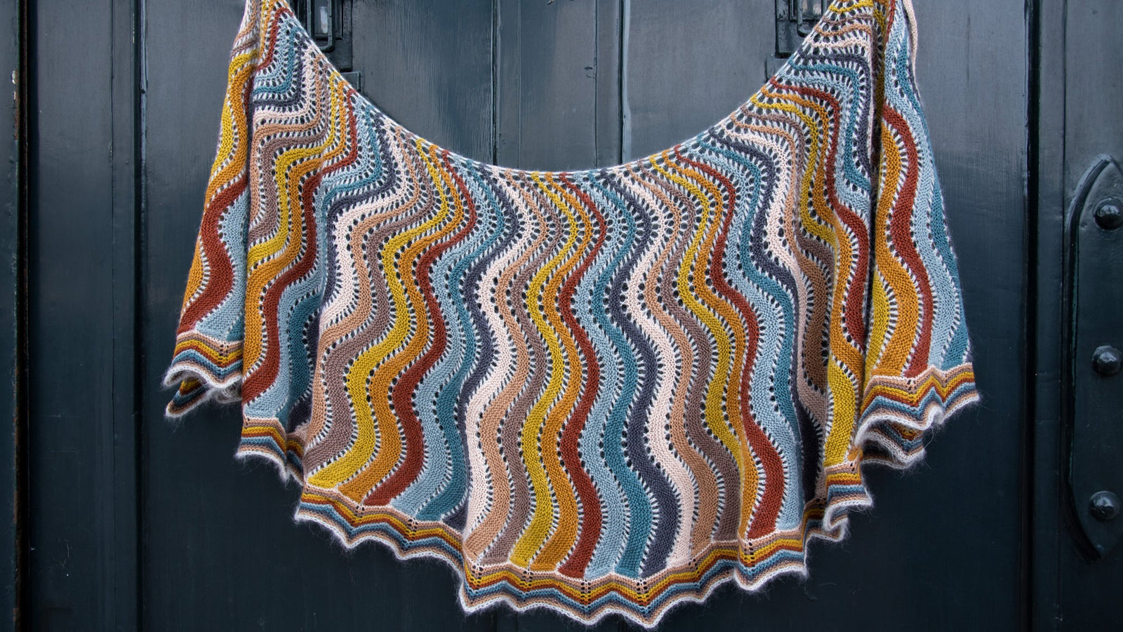 This image shows a beautifully knitted multicolour sample of the Replendence Shawl by Westknits. 